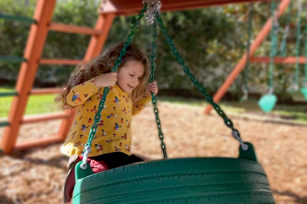 Girl in tire swing.