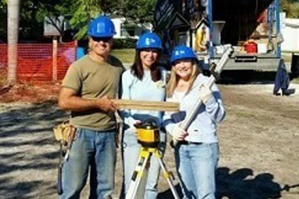 three people smiling at construction site.