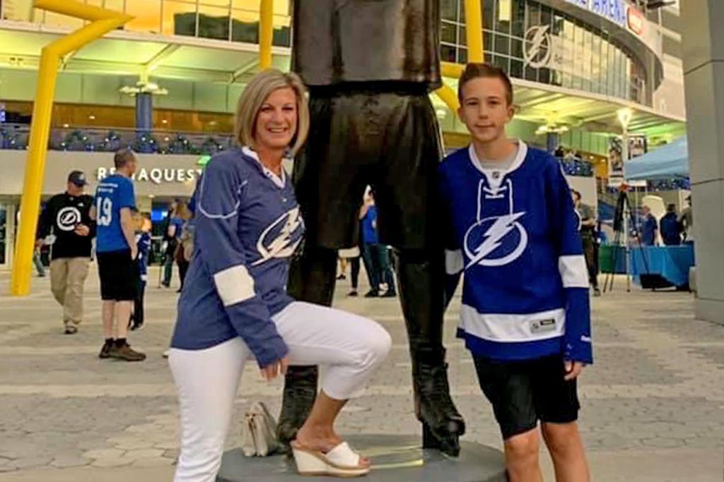 Mom and son standing in front of statue at Amalie Arena.
