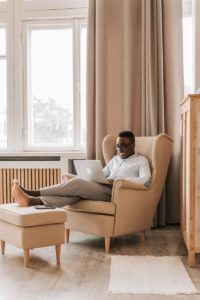 person in chair with laptop on lap