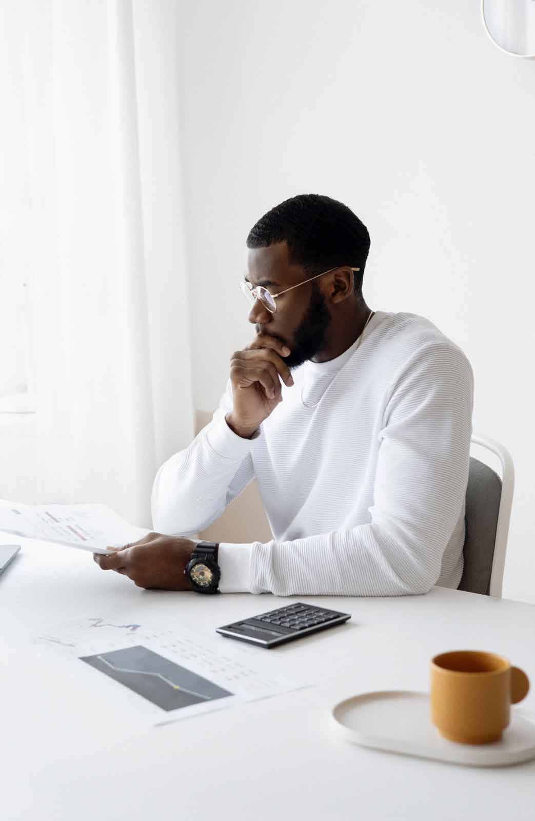 Man with hand on chin looking at paper