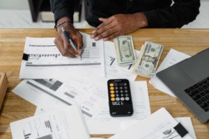 person at desk working on finances with calculator