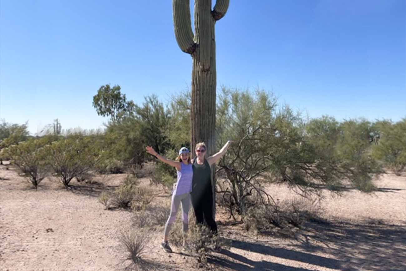 Tracie and her daughter standing in front of a giant cactus
