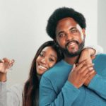 couple holding keys to a new house