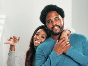 couple holding keys to a new house