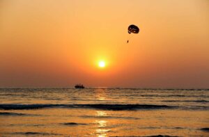 Sunset with boat pulling parasail on the horizon